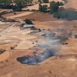 Cuatro medios aéreos y cinco terrestres luchan contra un incendio forestal que afecta a un terreno agrícola muy cerca de casas habitadas en el término municipal de Robledillo de Mohernando